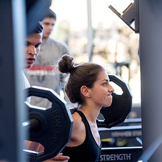 Girl lifting weights at ɫ rec center