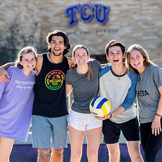 Five ɫ students on the sand volleyball court