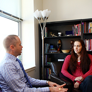 Rev. Todd Boling of ɫ Religious and Spiritual Life talks to a student in his office.